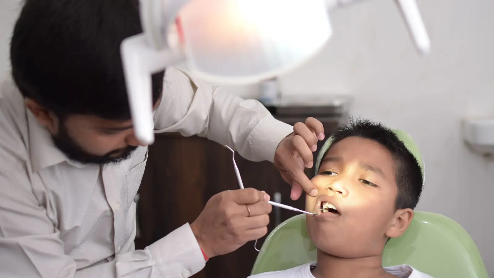 A dentist checking a boy's teeth